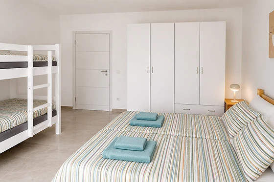 Ložnice s manželskou postelí a palandou v apartmánu Pushim